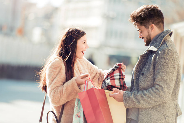 Gelukkige jonge paar met zakken in winkels - Foto, afbeelding