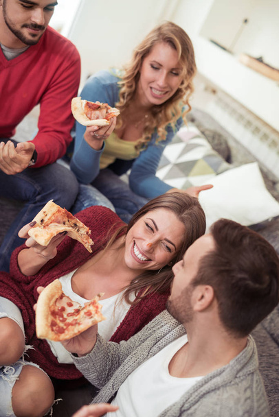 Gruppe fröhlicher junger Leute isst Pizza - Foto, Bild