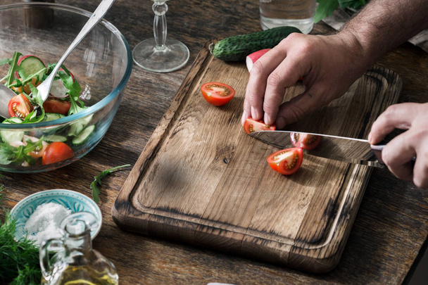 Man preparing salad on a wooden table - Photo, image