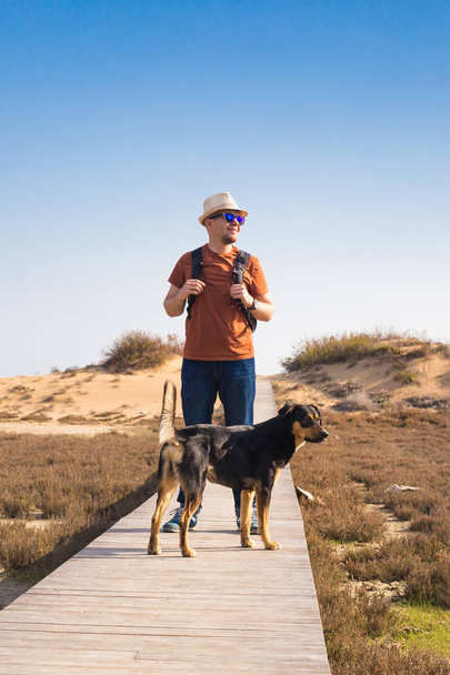 Outdoors lifestyle image of travelling man with cute dog. Tourism concept. - Photo, Image