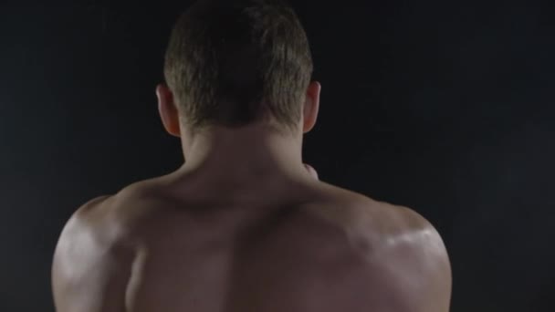 Punching. Muscular man boxing on black background. Boxer practicing shadow boxing - Filmagem, Vídeo