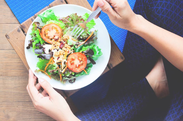 Woman in yoga clothing eating salad, Healthy lifestyle - Photo, Image