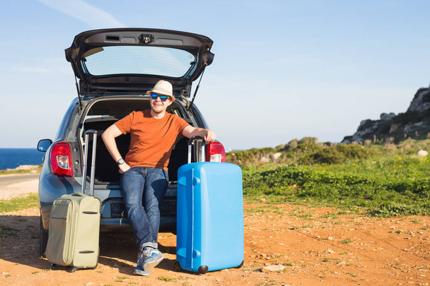 Путешествия, отдых, летняя поездка и концепция людей - человек собирается в отпуск, чемоданы в багажнике автомобиля
 - Фото, изображение