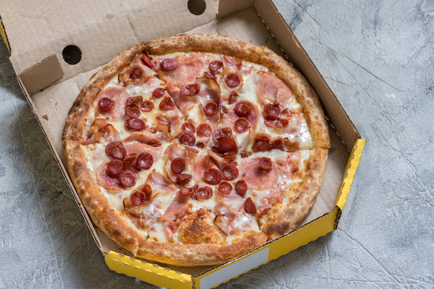 Pizza in box on concrete table, closeup - Фото, изображение