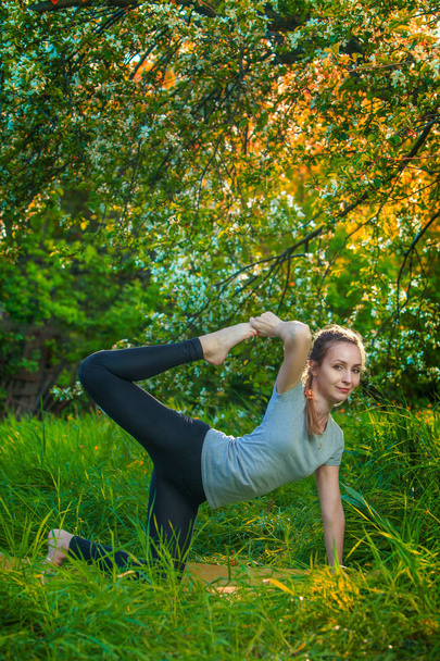 schöne Frau macht Yoga im Freien auf grünem Gras - Foto, Bild