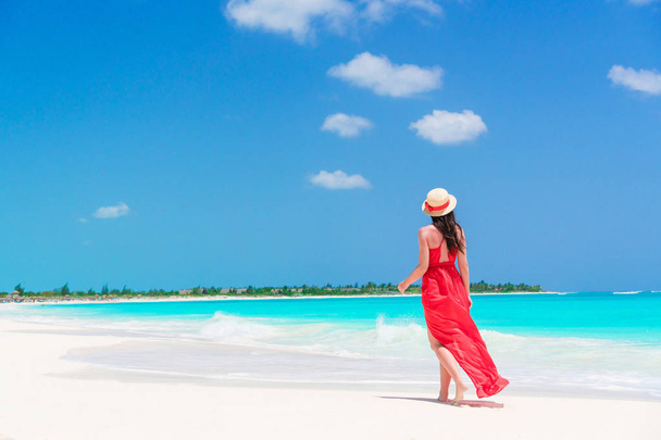 Giovane bella donna sulla riva del mare tropicale. Indietro vista di giovane ragazza in abito rosso sfondo il mare
 - Foto, immagini