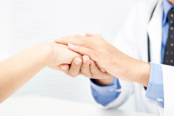 Médico sosteniendo paciente mano con cuidado, dando comodidad
 - Foto, imagen