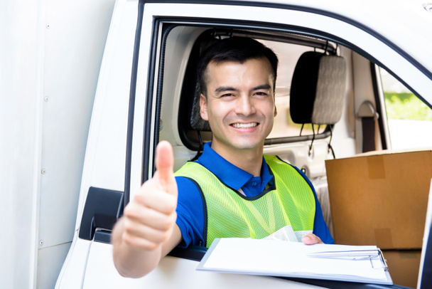 Delivery man sitting in the car as a driver, giving thumbs up - Photo, Image