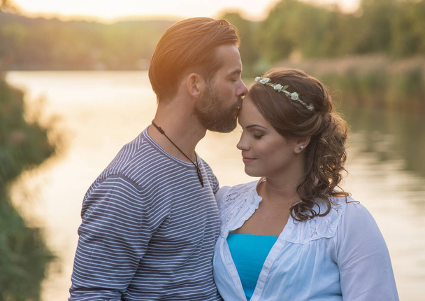 encantadora pareja besándose cerca del lago
 - Foto, Imagen