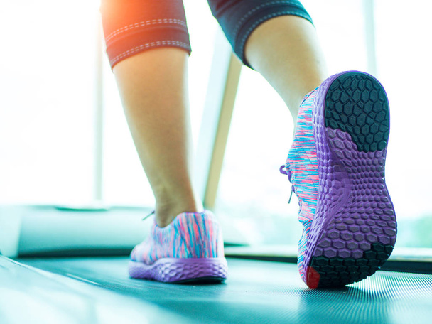 Frauenschritt und Laufen auf dem Laufband im Fitnessstudio - Foto, Bild