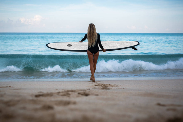 woman with surfing board standing on beach - Fotoğraf, Görsel