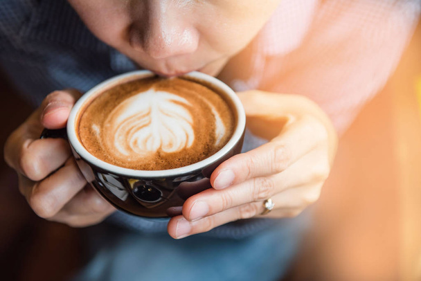 Frauen halten morgens im Café eine heiße Tasse Kaffee in der Hand   - Foto, Bild