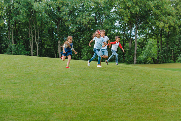 Multiethnische Kinder rennen im Park  - Foto, Bild