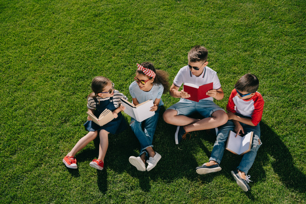 Children reading books in park - Foto, imagen
