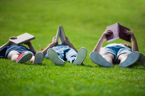 Children reading books in park - Foto, afbeelding