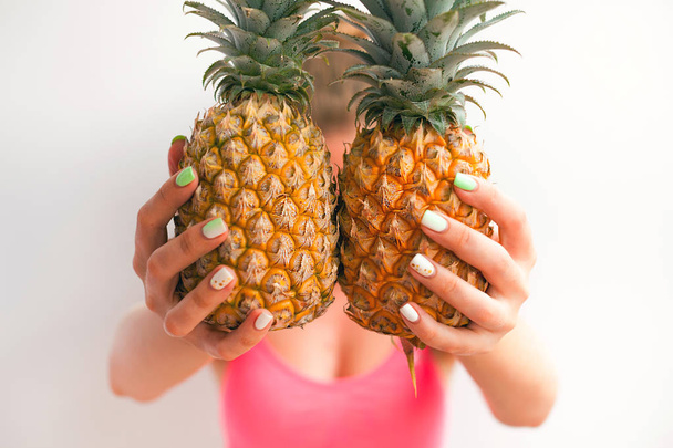 Portrait of a pretty young summer girl holding pineapple isolated over  background. Concept of a healthy lifestyle. - Foto, Imagem
