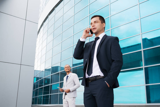 businessman talking on the phone in the background of the business center, and other businessman - Photo, image