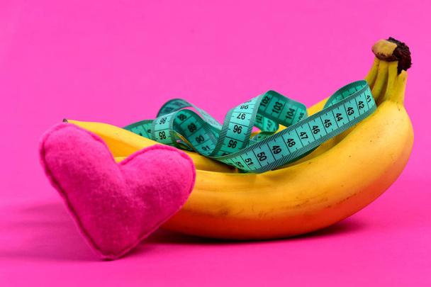 Heart near bunch of bananas with measuring tape - Foto, imagen