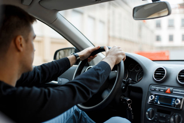 Arabada oturan ve direksiyonu tutan genç erkek sürücü - Fotoğraf, Görsel
