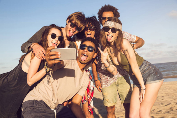 陽気な民族の友人 selfie をビーチで晴れた日に撮影 - 写真・画像