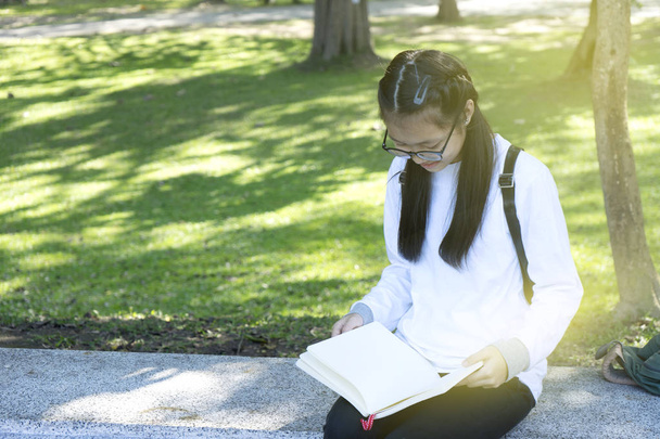 asiático chica relax sentarse recta pierna hold ocio libro
 - Foto, Imagen