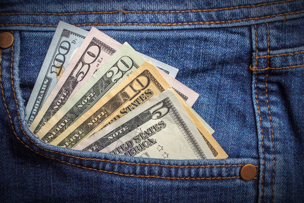 банкноти доларів у джинсовій кишені крупним планом. Бізнес-концепція. кишенькові гроші
. - Фото, зображення