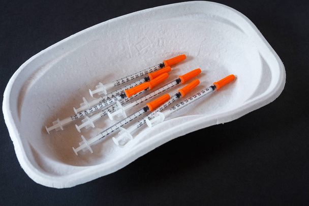 Jeringas de insulina para la diabetes en un recipiente de papel. Instrumentos médicos
 - Foto, imagen