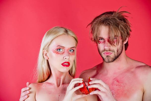 young couple of woman and man with makeup hold pomegranate - Photo, Image
