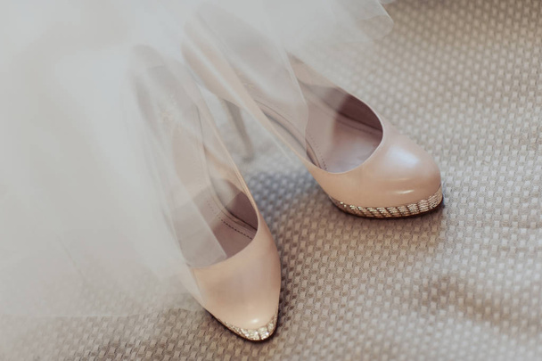 Zapatos de novia de boda con tacones altos y pendientes brillantes de plata en la ropa de oveja
 - Foto, imagen