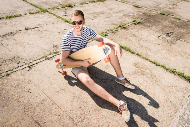 Man holding skateboard - Valokuva, kuva