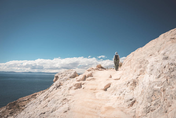 Backpacker explorando trilhas majestosas da inca na Ilha do Sol, Lago Titicaca, destino de viagem cênica na Bolívia. Aventuras de viagem e férias nas Américas. Imagem tonificada
. - Foto, Imagem