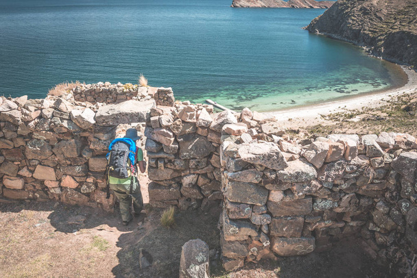 Turista explorando el antiguo misterioso asentamiento laberíntico Inca, llamado Chinkana, en la Isla del Sol, Lago Titicaca, Bolivia. Aventuras de viaje las Américas. Imagen tonificada
. - Foto, Imagen