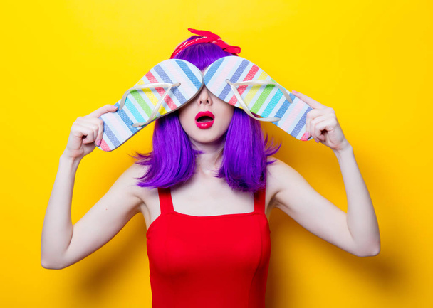 молодая женщина с разноцветными шлепанцами
 - Фото, изображение