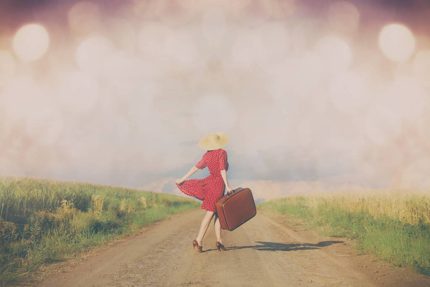 Женщина с чемоданом на дороге
  - Фото, изображение