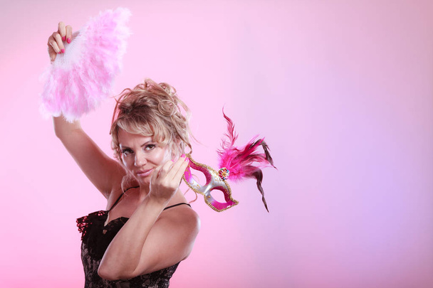 Woman holding carnival mask feather fan in hand - Zdjęcie, obraz