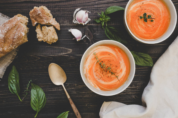 Tomato cream soup with bread on the wooden table, top view - 写真・画像