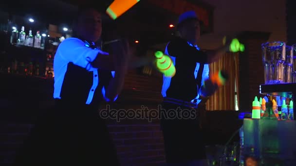 Pokaz barmański. Dwóch barmanów żonglować butelek i zlewki do mieszania. zwolnionym tempie - Materiał filmowy, wideo