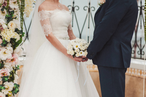 Невеста проводит большой свадебный букет на свадебной церемонии - Фото, изображение