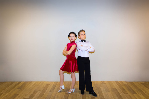 Młody chłopak i dziewczyna pozuje w studio tańca na szaro. Koncepcja tańca towarzyskiego - Zdjęcie, obraz