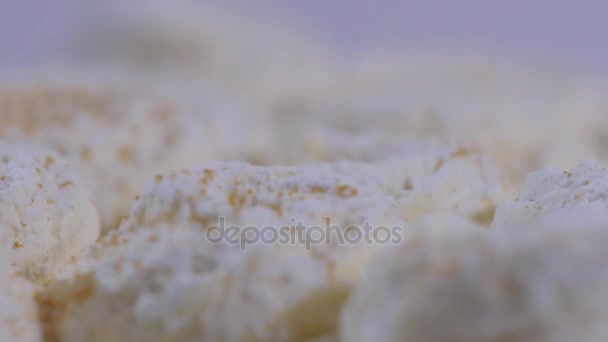 Sladká bílá sněhová pusinka na bílém pozadí. Bílé čokoládové dorty v bílém deska - detail - Záběry, video