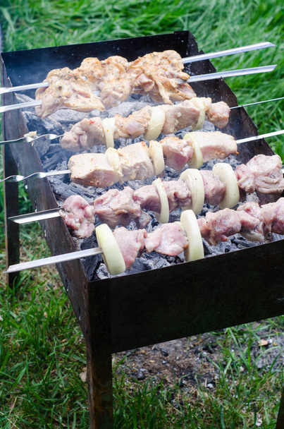 Marynowane szaszłyk lub shish kebab, surowego mięsa grillowanie na metalowy szpikulec, z bliska. Selektywny fokus - Zdjęcie, obraz