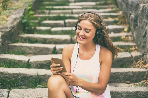 Young woman with headphones using mobile phone - Foto, Imagem