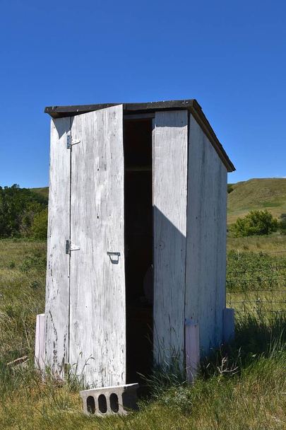 Door partially open on an old white outhouse - Photo, Image