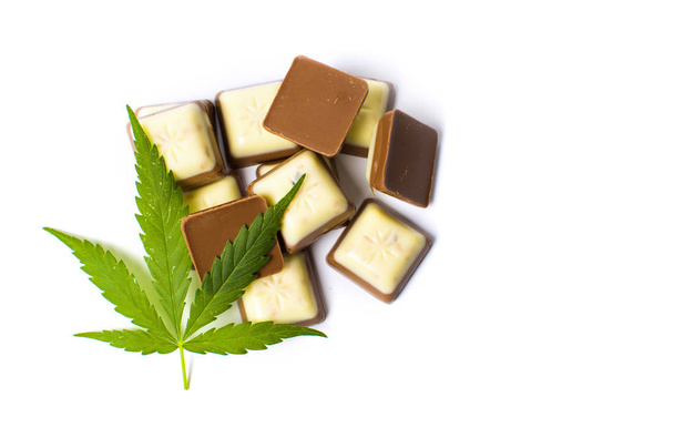 Hoja de marihuana encima de trozos de chocolate
 - Foto, Imagen