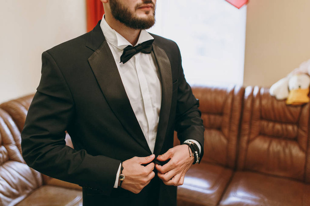 eleganter Bräutigam in Hochzeitsjacke mit weißem Hemd und türkisfarbener Krawatte. Bräutigam im blauen Anzug. - Foto, Bild