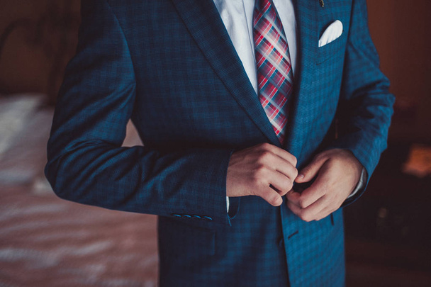 Élégant marié vêtu d'une chemise blanche et d'une cravate turquoise. Les mains de Groom sur costume bleu
. - Photo, image