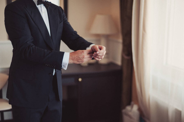 Elegant groom in wedding jacket wearing white shirt and turquoise tie. Groom's hands on blue suit. - Zdjęcie, obraz