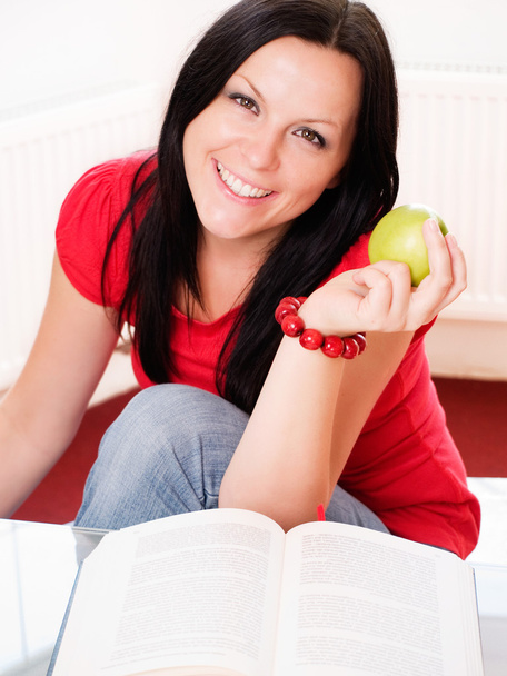 Smiling brunette woman holding an apple - Foto, Imagem
