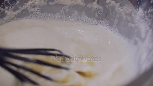 A woman stirs a dough for pancakes in a bowl. - Filmmaterial, Video