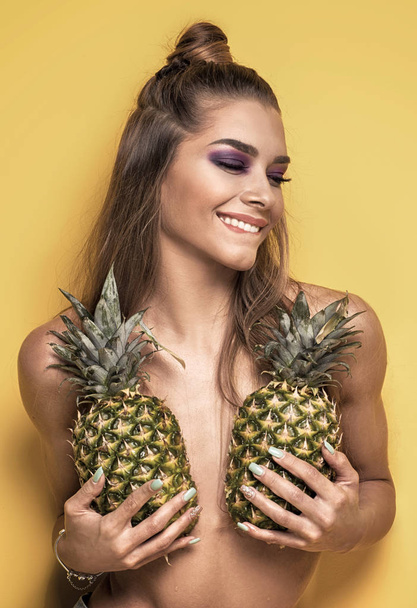 Young crazy girl with pineapples. - Foto, afbeelding